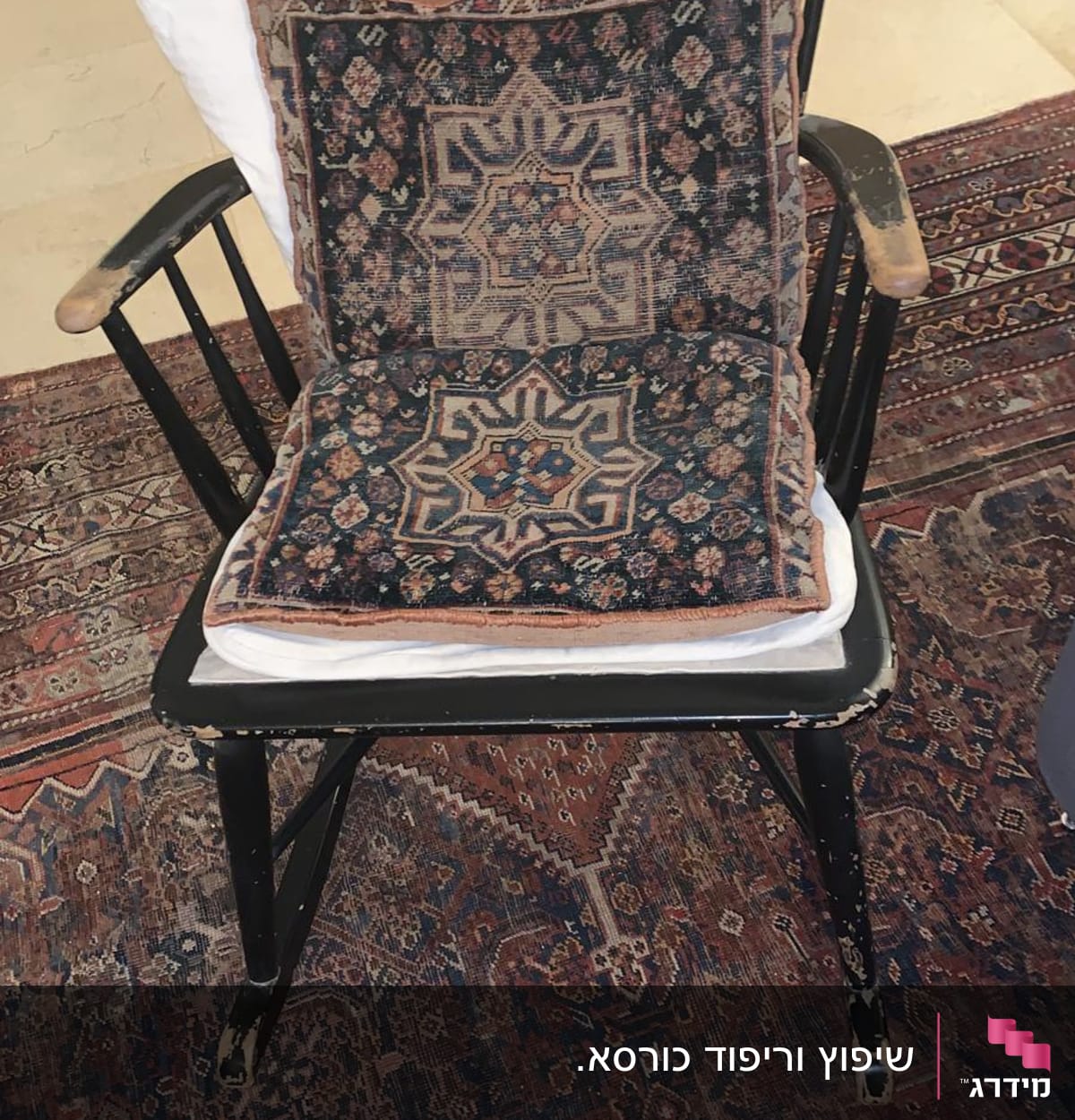 כרית עם דוגמת שטיח על כיסא עץ שחור